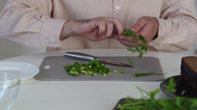 A chef professionally prepares a fresh vegetable salad, chopping potatoes, eggs, and greens. Dynamic cooking process showcasing culinary skills and healthy food preparation