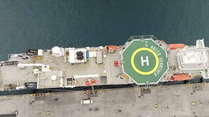 Ponta Delgada, Portugal - 17 September 2025: Aerial view of the Argeo Searcher vessel docked, its helipad a vibrant green against the ship's muted tones.