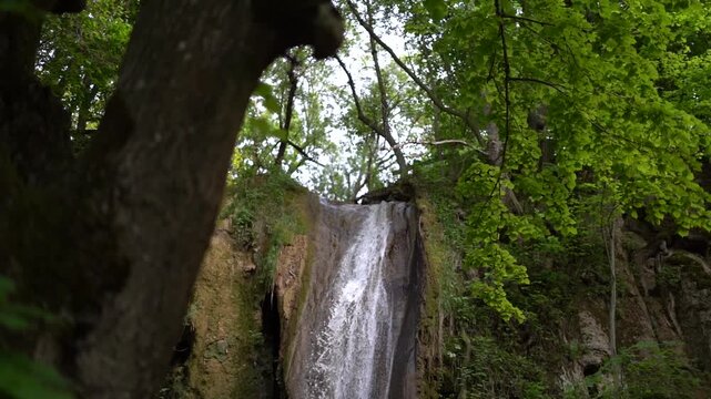 Blederija waterfall on Mount Ozren in Eastern Serbia. Cliff scene surrounded by forest with a waterfall on a mountain stream. The camera slowly orbits around the scene