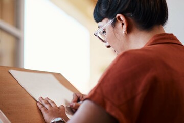 Artist, drawing and learning on paper in studio process of creativity at college with project. Art, student and woman planning sketch with pencil on board in university workshop with talent or skill
