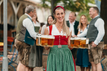 Traditional woman waitress serves large beer mugs to friends in Bavarian costumes enjoying Oktoberfest friendship leisure and festive culture
