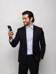 man in  suit is smiling and holding  cell phone