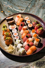 Colorful sushi platter with assorted nigiri, maki and gunkan featuring fresh salmon, tuna and seafood, artfully arranged for an authentic japanese dining experience