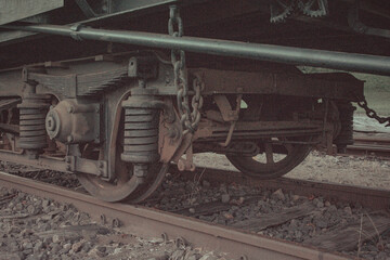Naklejka premium Close up view of rusty train wheel with metal suspension and chain