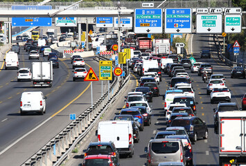 Tr&aacute;fico, retenci&oacute;n, atasco, obra en carretera y calle m30 con coches, camiones y furgonetas en operaci&oacute;n salida de viaje entre carteles y se&ntilde;ales en hora punta en Madrid
