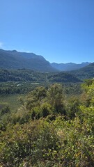 Fototapeta premium Breathtaking view of mountains in southern Chile, with lush slopes and peaks under clear skies. A serene and majestic natural landscape.