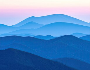 Misty mountain ranges layered in shades of blue and purple at dawn