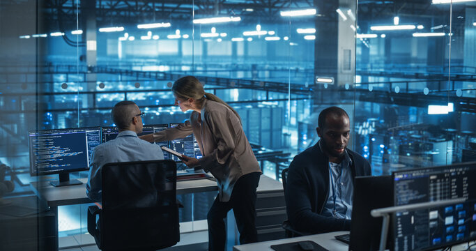 Modern Office in a Server Facility: Female Data Scientist and Male Cybersecurity Expert Analyze Data Together on a Desktop Computer, Brainstorming New Security Solutions and Services