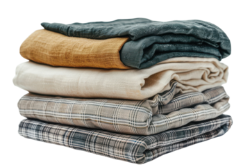 A stack of folded clothes shows a mix of linen shirts and plaid fabrics, suggesting a minimalist or natural style. The texture emphasizes textile design and wardrobe simplicity.