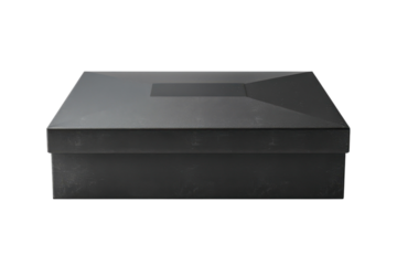 Moody closeup of a dark, angular box against a black background. Minimalist presentation highlights its geometric shape and solid, textured tone.