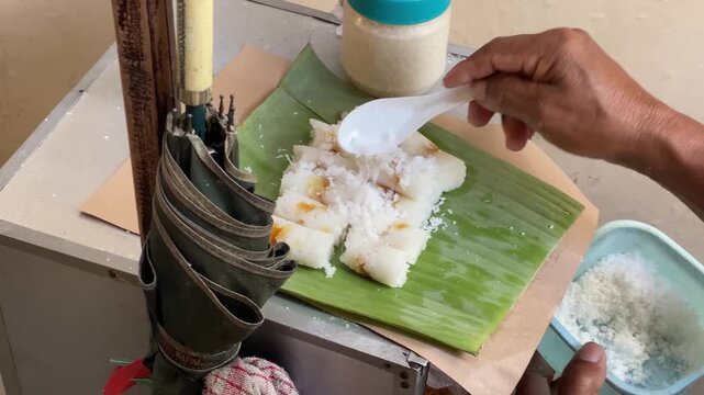Putu Bambu is a warm, sweet, steamed, cylindrical rice cake with a sweet palm sugar filling, traditionally steamed in a bamboo tube and served with grated coconut and a little sugar.