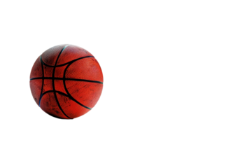 A wellused basketball, intensely lit, appears suspended against a stark black background. The image highlights texture and drama.