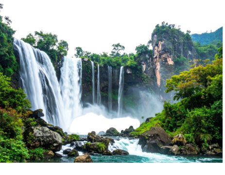 Lush waterfall cascading down rocky cliffs into a serene pool, surrounded by verdant jungle