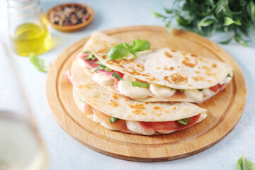 Traditional Italian dish Piadina romagnola - flat bread with mozarella and proscuitto	