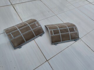 two air filters from the air conditioner that were dirty and dusty