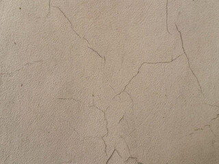 Old beige wall with cracked and peeling paint texture. Vintage brown color weathered surface perfect for grunge, architecture, and background design projects