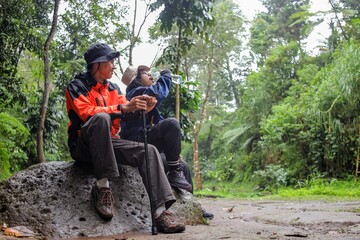 Hikers Resting On Trail Drinking Water After Long Hike While Enjoying The Forest