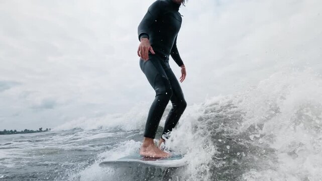 Surfer skillfully rides a wave, showcasing balance and control in dynamic ocean scene