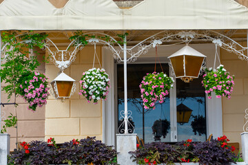 Balcony with hanging flower baskets, lanterns, and colorful decorative plants