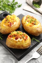 Tasty stuffed baked potatoes served on grey textured table, closeup