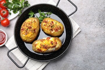 Tasty stuffed baked potatoes served on grey table, flat lay. Space for text