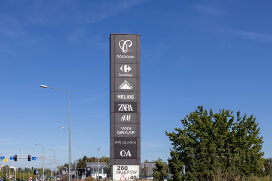 Poznan, Poland - September 20, 2025: Posnania shopping center's vertical pylon sign displaying logos for Carrefour, Zara, H&M, Primark, C&A, a consumer guide