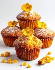 Four Golden Muffins Stacked on White with Yellow Flowers and Corn Kernels