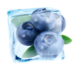 Ripe blueberries and green leaves in ice cube against white background
