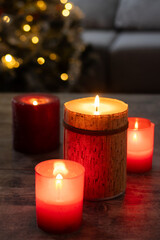 Red Christmas candles with holiday lights and christmas tree in background. Copy space