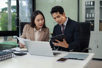 Business team analyzing documents, graphs, and data with a laptop, tablet, and smartphone. Collaboration, strategy, and success.