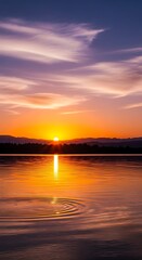 A serene sunrise paints the tranquil lake with warm hues, showcasing a tranquil atmosphere reflected in the still water.