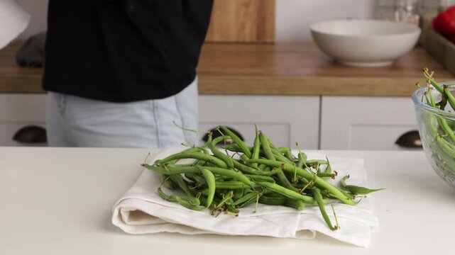 hands dried green beans on linen table cooking food