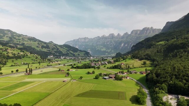 Scenic Aerial View of a Valley with Green Fields and Mountain Landscape in Switzerland near Flums, Berschis, and Walenstadt in the Canton of St. Gallen &ndash; Drone Footage