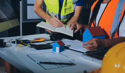 Closeup of team of industrial engineers meeting analyze machinery blueprints consult project on table in manufacturing factory. Working in manufacturing plant or production plant.