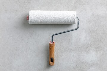 Fototapeta premium Long Handle Roller Brush Applying White Primer on Cement Wall for Renovation