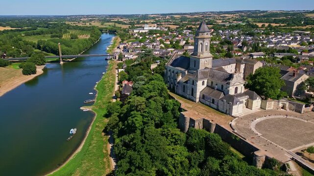 Aerial of Abbey Church Saint Florent, river and Loire Valley landscape in background, panoramic pullback midday