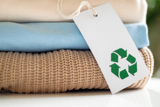 Eco-friendly clothing with recycle label on soft textile stack for sustainable fashion concept