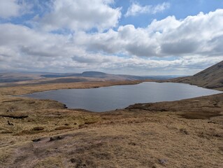 Mountain lake in the Brecon Beacons under a partly cloudy sky