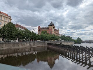 Fototapeta premium Historic riverside architecture and reflections along the Vltava River in Prague