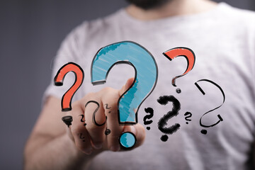 Image depicts a man interacting with question marks, signifying inquiry, doubt, and uncertainty. Ideal for concepts like FAQ, problem-solv