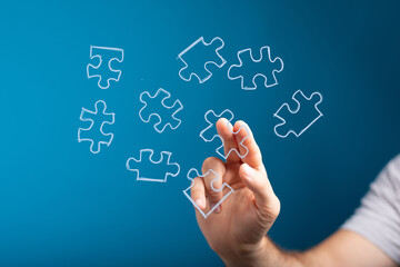 Obraz premium Hand holding puzzle piece, symbolizing problem-solving, teamwork, and strategic planning. Ideal for business and technology.