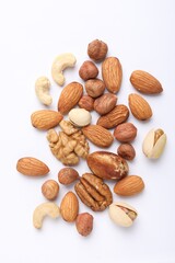 Mix of different nuts on white background, flat lay