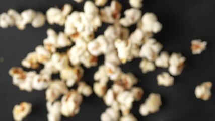 Slow motion shot of fresh popcorn flying towards camera on black background. Premium snack footage perfect for cinema commercials and entertainment marketing content. - Powered by Adobe