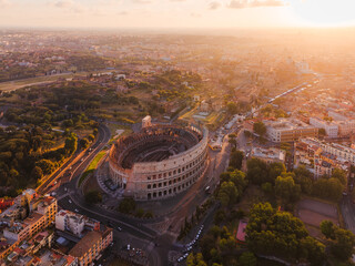 Aerial view of the Colosseum bathed in golden light, its ancient stones echoing tales of gladiators against the vibrant cityscape, Roma, Lazio, Italy.