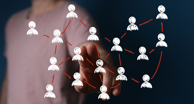 Hand interacting with a network of people icons.  Illustrates connection, community, collaboration, and social media.