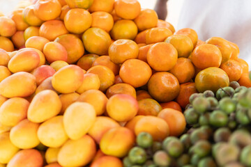 Fresh oranges and mangos in a vibrant fruit market stall