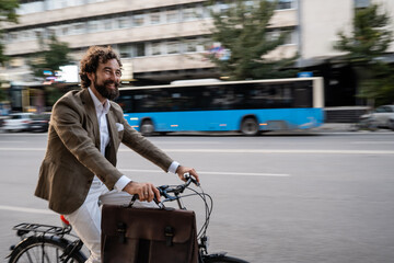 Naklejka premium Businessman cycling in the city with briefcase and passing bus