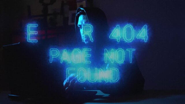 Mysterious hacker in hoodie and mask typing on laptop glowing with error 404 message in darkness. Perfect for cyber attack, data theft, and security breach themes.