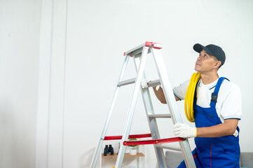 Painter on Ladder: A dedicated painter stands on a sturdy ladder, diligently preparing to paint, embodying the meticulous attention to detail and the drive for perfection required in home renovation.