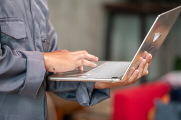Technology Technician Working on Laptop: A skilled technician, clad in professional attire, engrossed in work using a state-of-the-art laptop. This image showcases efficiency and technical acumen.